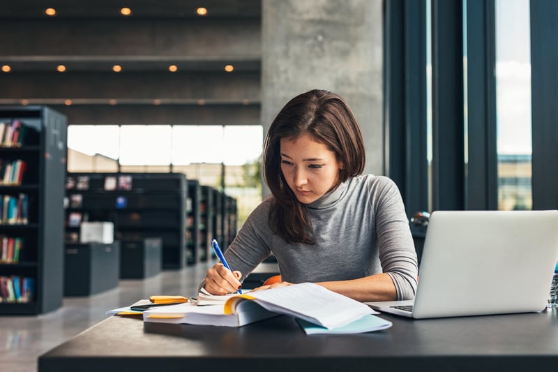 Woman studying in a library before retaking the LSAT