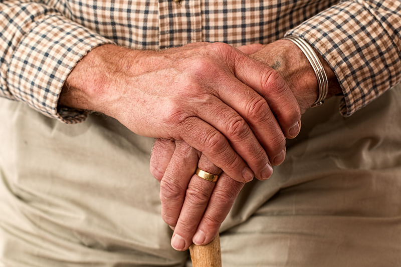 Elderly hands on a cane