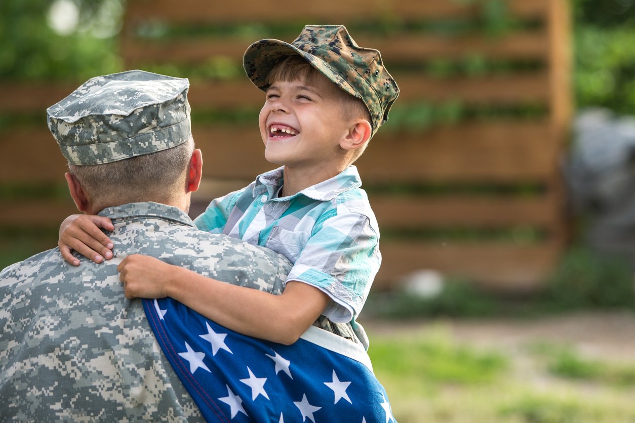 a veteran man hugging his child